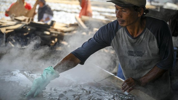 Pekerja membawa ikan asin untuk proses penjemuran di Muara Angke, Jakarta, Jumat (25/10/2024). Produksi ikan asin di kawasan tersebut dalam beberapa pekan terakhir mengalami penurunan hingga 40 persen dari biasanya karena kurangnya pasokan bahan baku dari nelayan. ANTARA FOTO/Muhammad Ramdan/wpa.