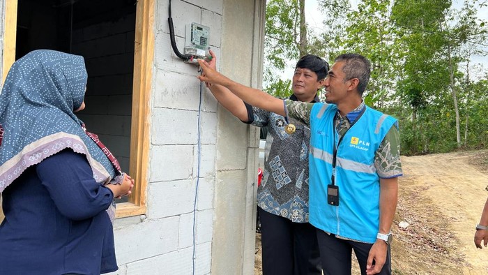 Manager PLN UP3 Cilacap, Ricki Yakop bersama Pj Bupati Cilacap Muhammad Arief Irwanto secara simbolis penyalaan listrik gratis di rumah Ibu Menik, salah satu penerima LUTD.