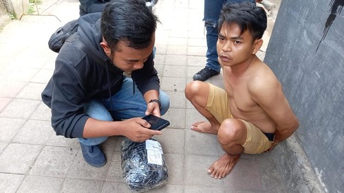 Pengedar narkoba berinisial HS ditangkap saat menerima paket ganja 1,3 kg di salah satu kantor jasa pengiriman barang di Kota Mataram, NTB, Jumat (25/10/2024). (Dok. Polresta Mataram)
