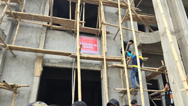 Petugas memasang spanduk penyegelan rumah mewah milik bos skincare di Makassar.