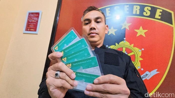 Polisi menunjukkan kartu BPJS palsu.