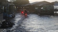 Wisatawan menerjang air laut di kawasan wisata Pantai Pondok Bali saat air pasang.