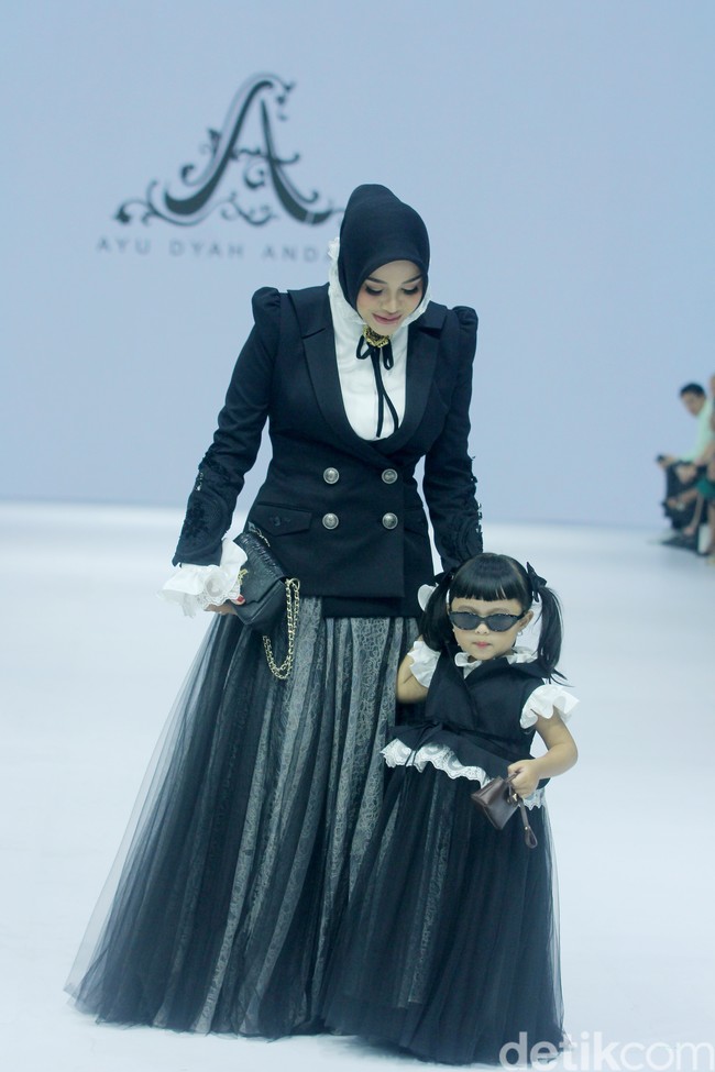 Ketika berjalan di runaway JFW, kehadiran Aurel bersama Ameena mencuri perhatian. Selain Aurel yang tampak semakin langsing, penampilan Ameena juga menggemaskan. Ameena memakai kacamata hitam dan mengenakan baju yang senada dengan Aurel.  Foto: Mohammad Abduh/detikcom.