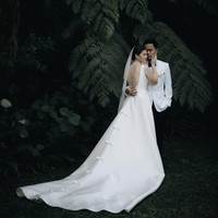 Anthony dan Mitzi tampil kompak dalam balutan busana pengantin berwarna putih. Mitzi memilih gaun backless berekor tanpa lengan. Sementara Anthony mengenakan jas putih dipadukan dasi kupu-kupu dan celana panjang hitam. Foto: Instagram/@sinisukanthony