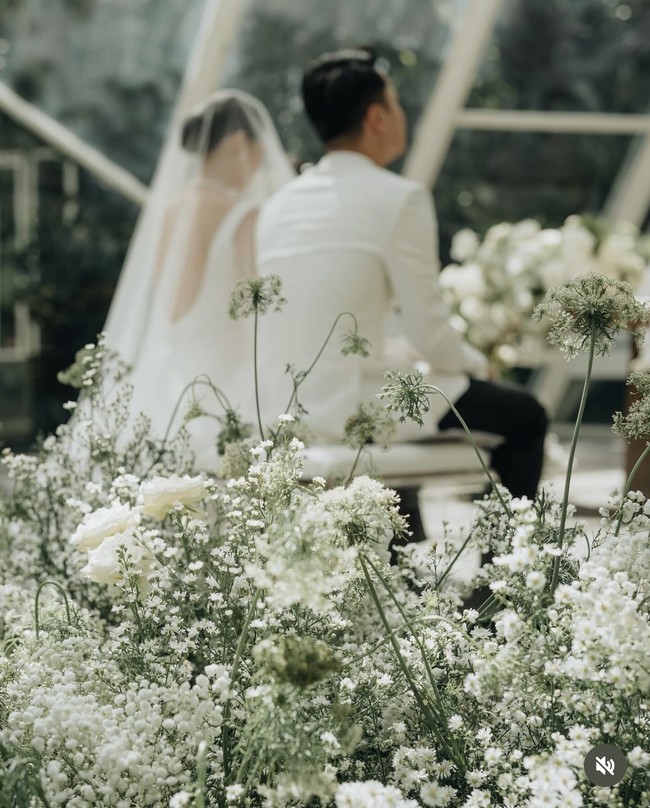 Senada dengan busana pengantin yang dikenakan, dekorasi pernikahan Mitzi juga terlihat elegan dengan nuansa warna putih. Bunga jenis baby breath putih dipadukan dengan mawar putih. Foto: Instagram/@sinisukanthony
