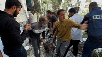 Warga mengevakuasi jenazah korban serangan Israel tersebut.
