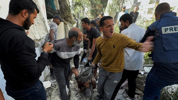 Palestinians inspect the site of an Israeli strike on a school sheltering displaced people, amid the ongoing Israel-Hamas conflict, in Gaza City, October 27, 2024. REUTERS/Ayman Al Hassi