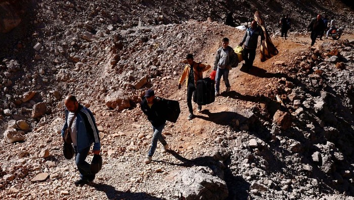 ISRAEL-PALESTINIANS/LEBANON-SYRIA Children cross from Lebanon into Syria on foot at the Masnaa border crossing, after an Israeli strike, as they flee the ongoing hostilities between Hezbollah and Israeli forces, in Al Masnaa, Lebanon October 27, 2024. REUTERS/Yara Nardi
