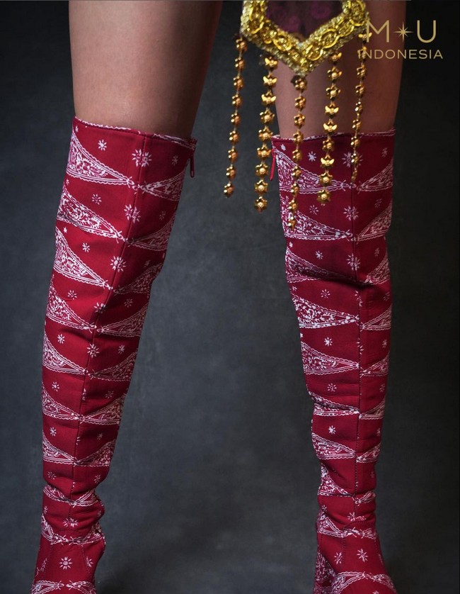 Tak hanya tenun, kostum juga memadukan kain batik. Clara mengenakan sepatu boots merah dengan motif batik tumpal warna putih. Foto: Instagram/@missuniverseindonesia2024