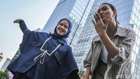 Seorang anak berkebutuhan khusus down syndrom tampil didampingi seorang model saat Fashion Show Street Down Syndrom di Jalan Sudirman, Jakarta, Minggu (27/10/2024).