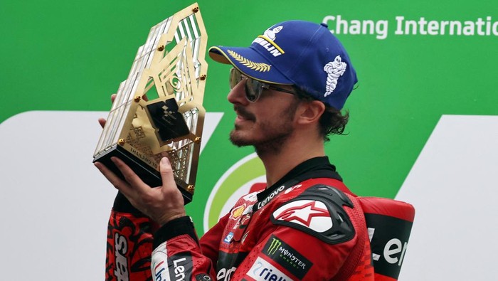 MotoGP - Thailand Grand Prix - Chang International Circuit, Buriram, Thailand - October 27, 2024 Ducati Lenovo Teams Francesco Bagnaia celebrates with the trophy on the podium after winning the MotoGP REUTERS/Athit Perawongmetha