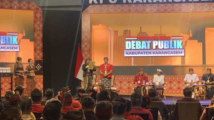 Paslon cabup-cawabup Karangasem nomor urut 1, I Wayan Kari Subali-I Ketut Putra Ismaya Jaya (Karisma) saat memaparkan visi-misi dalam debat publik perdana Pilbup Karangasem di Nusa Dua, Badung, Minggu (27/10/2024). (Foto: Rizki Setyo/detikBali)