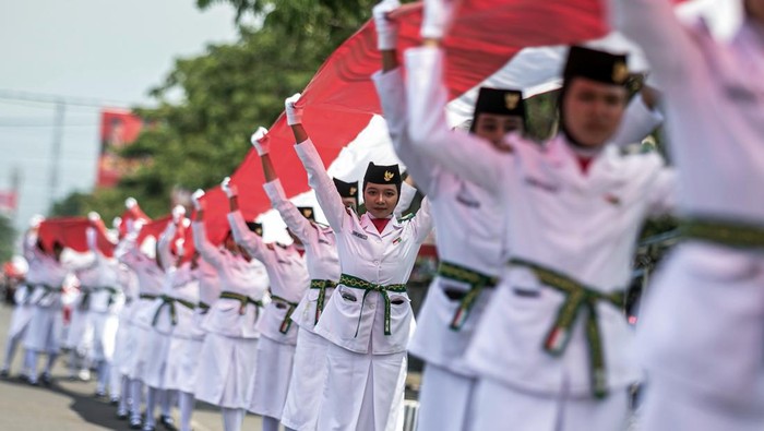 Anggota Paskibra membentangkan bendera Merah Putih sepanjang seribu meter di Karanganyar, Jawa Tengah, Minggu (27/10/2024). Kegiatan yang diikuti pelajar dan organisasi masyarakat tersebut dalam rangka peringatan Ke-96 Hari Sumpah Pemuda sekaligus upaya meningkatkan semangat cinta tanah air, persatuan dan kesatuan kepada generasi muda. ANTARA FOTO/Mohammad Ayudha/agr
