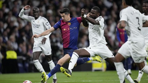 Barcelonas Robert Lewandowski fights for the ball against Real Madrids Antonio Rudiger during a Spanish La Liga soccer match between Real Madrid and Barcelona at the Santiago Bernabeu stadium in Madrid, Spain, Saturday, Oct. 26, 2024. (AP Photo/Bernat Armangue)