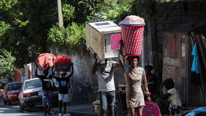 Warga Haiti Mengungsi gegara Teror Geng Bersenjata People carry their belongings along a street as they flee their homes from gang violence, in Port-au-Prince, Haiti, October 26, 2024. REUTERS/Ralph Tedy Erol TPX IMAGES OF THE DAY