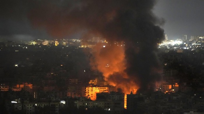 Flame and smoke rises from buildings hit by Israeli airstrikes on Dahiyeh, in the southern suburb of Beirut, Lebanon, early Sunday, Oct. 27, 2024. (AP Photo/Hussein Malla)