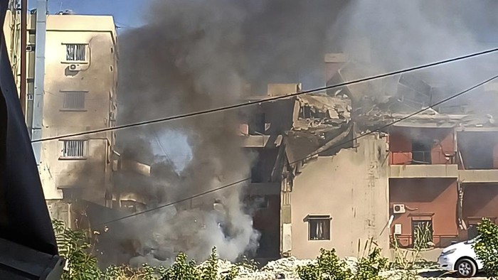 A Lebanese soldier asks journalists to move away from the scene near a building hit in an Israeli airstrike, in the southern port city of Sidon, Lebanon, Sunday, Oct. 27, 2024. (AP Photo/Mohammad Zaatari)