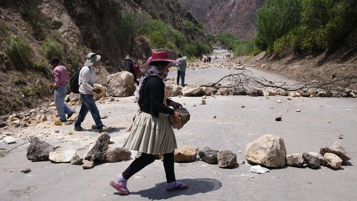 Aksi Pendukung Eks Presiden Bolivia Blokir Jalan dengan Batu Stones and debris lie on the road after supporters of Bolivian former President Evo Morales placed them there to prevent him from facing a criminal investigation over allegations of abuse of a minor and to demonstrate against an alleged assassination attempt, near Cochabamba, Bolivia, Sunday, Oct. 27, 2024. (AP Photo/Juan Karita)