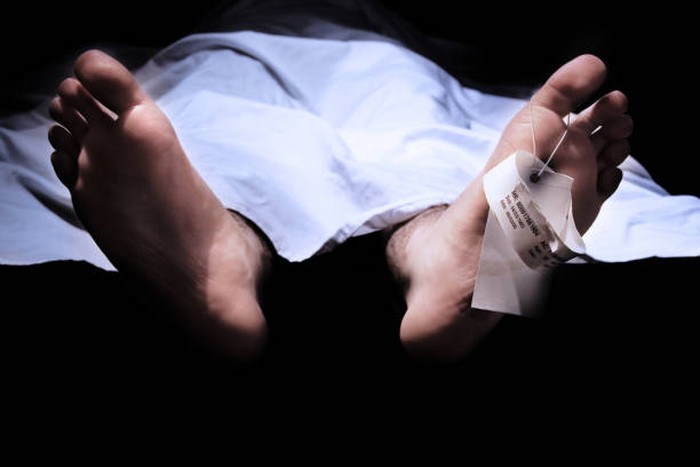 Conceptual shot of feet with a hospital information ring and tag representing death
