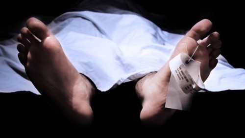 Conceptual shot of feet with a hospital information ring and tag representing death