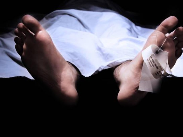 Conceptual shot of feet with a hospital information ring and tag representing death