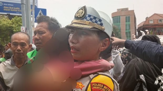 Kasat Lantas Jaksel Kompol Yunita Rungkat membawa bocah yang disandera usai pelaku dilumpuhkan polisi, di Pospol Pejaten, Jaksel, Senin (28/10/2024).