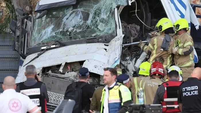 Israeli police and emergency responders recover the body of the truck driver at the site of a ramming attack in Ramat Hasharon, north of Tel Aviv on October 27, 2024. (AFP)