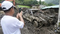 Sebelumnya, material longsor telah menimbun seluruh bodi mobil ini.