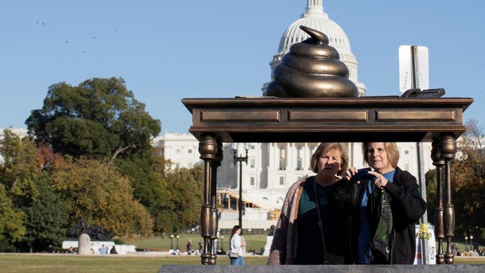 Patung Kotoran Muncul di Depan Gedung DPR AS A new temporary statue of a brass-colored desk with a large poop-shaped emoji on top of it, referencing those who attacked the U.S. Capitol on January 6, 2021, is seen near the Capitol in Washington, U.S., October 25, 2024. REUTERS/Kaylee Greenlee Beal