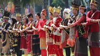 Peserta yang berbusana adat dari berbagai daerah di Indonesia saling bergandengan tangan saat pembacaan teks Keputusan Kongres Pemuda Indoensia 1928 pada upacara peringatan Hari Sumpah Pemuda di halaman Gedung Negara Grahadi, Surabaya, Jawa Timur, Senin (28/10/2024). Peringatan tersebut mengusung tema Maju Bersama Indonesia Raya. ANTARA FOTO/Moch Asim 