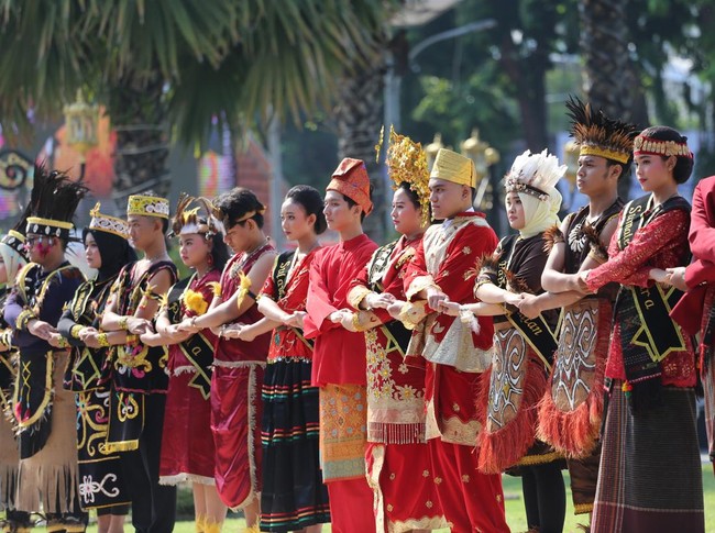 Peserta yang berbusana adat dari berbagai daerah di Indonesia saling bergandengan tangan saat pembacaan teks Keputusan Kongres Pemuda Indoensia 1928 pada upacara peringatan Hari Sumpah Pemuda di halaman Gedung Negara Grahadi, Surabaya, Jawa Timur, Senin (28/10/2024). Peringatan tersebut mengusung tema Maju Bersama Indonesia Raya. ANTARA FOTO/Moch Asim/aww.