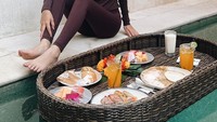 Ada juga momennya saat liburan ke Bali. Di hotel tempatnya menginap, ia menikmati floating breakfast. Ada menu roti, buah-buahan, hingga aneka sosis. Foto: Instagram @ratusfy_