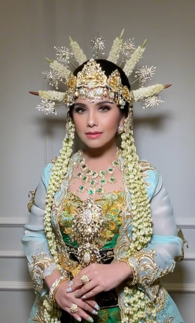 Untuk menyempurnakan penampilannya, Annisa juga terlihat mengenakan berbagai perhiasan pelengkap yang juga berwarna emas, seperti, gelang, cincin, anting, dan kalung. Kalungnya terlihat cantik bertahtakan batu-batu berwarna hijau, senada dengan busana yang dikenakannya. Foto: Instagram/@barry_irawan/@whulyan