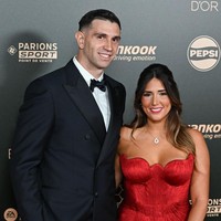 Pemain Aston Villa dan Timnas Argentina Emiliano Martinez meraih Yashin Trophy 2024 pada Gala Ballon d’Or 2024. Martinez hadir ditemani istrinya Mandinha Martinez yang tampil dengan gaun merah dengan kerah sweetheart, rok berlipit, dan korset dengan lipatan rumit. Foto: Corbis via Getty Images/Stephane Cardinale - Corbis
