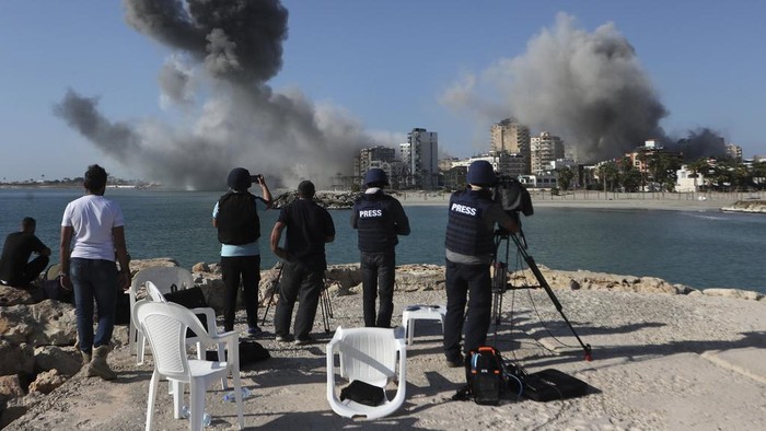 Gedung-gedung di Lebanon Luluh Lantak Diserang Israel Journalists film as smoke rises from buildings hit in Israeli airstrikes in Tyre, southern Lebanon, Monday, Oct. 28, 2024.(AP Photo/Mohammed Zaatari)