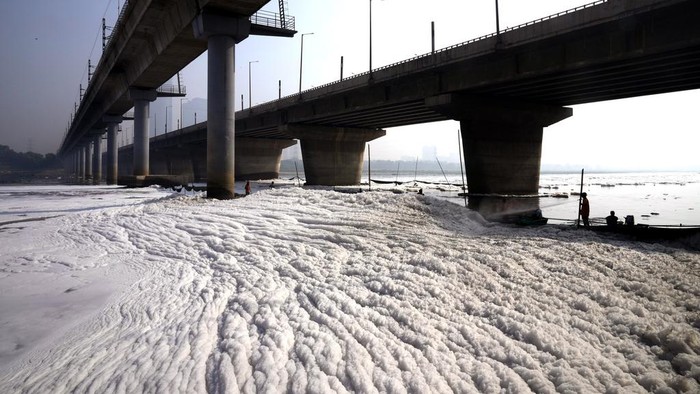 Workers for the Delhi Jal or water board spray chemical to clean the toxic foams in the river Yamuna in New Delhi, India, Tuesday, Oct. 29, 2024. (AP Photo/Manish Swarup)