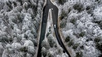 Mobil-mobil melaju ke puncak gunung Feldberg yang tertutup salju di dekat Frankfurt.