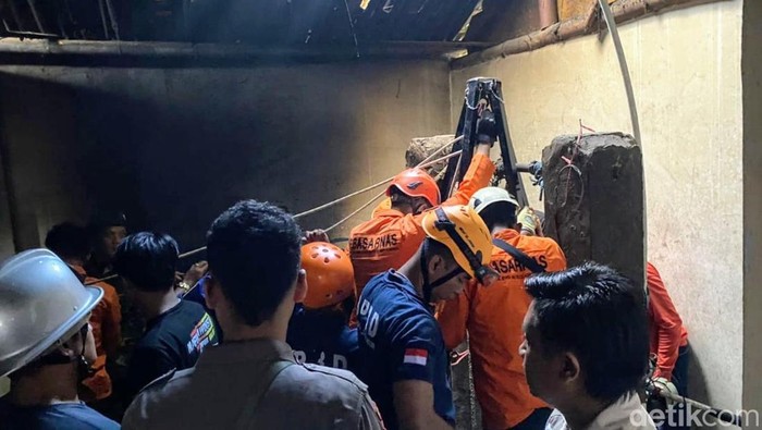 Petugas mengevakuasi korban yang terjatuh dari dalam sumur