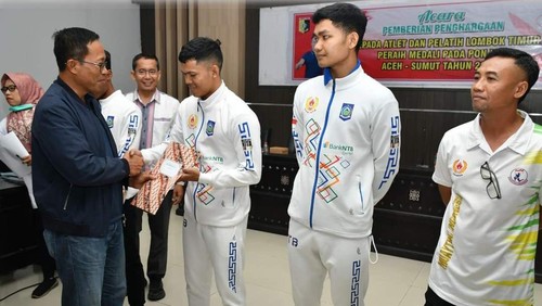 Pj Bupati Lombok Timur, Muhamad Juaini Taufik, menyerahkan bonus kepada atlet peraih medali PON XXI Aceh-Sumut, Selasa (29/10/2024). (Edi Suryansyah/detikBali)