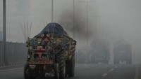 Traktor-troli melepaskan asap dan bergerak di jalan saat kabut asap menyelimuti Lahore, Pakistan, Senin (28/10/2024).