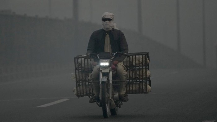 Vehicles move slow on a road as smog envelops the area, in Lahore, Pakistan, Monday, Oct. 28, 2024. (AP Photo/K.M. Chaudary)