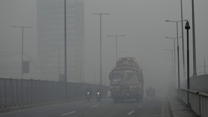 Vehicles move slow on a road as smog envelops the area, in Lahore, Pakistan, Monday, Oct. 28, 2024. (AP Photo/K.M. Chaudary)