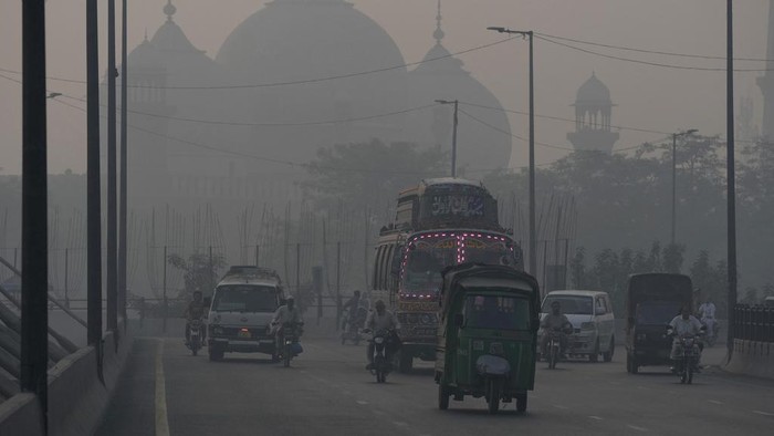 Vehicles move slow on a road as smog envelops the area, in Lahore, Pakistan, Monday, Oct. 28, 2024. (AP Photo/K.M. Chaudary)