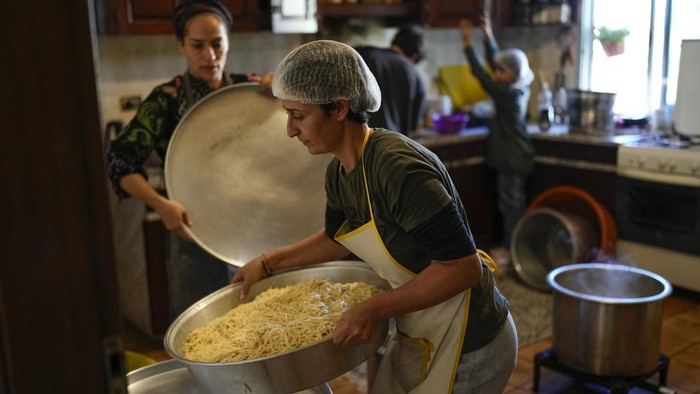 Pusat Seni Perempuan di Lebanon Disulap Jadi Dapur Umum Relawan memasak makanan untuk para warga yang terlantar di Lebanon. Relawan telah meningkatkan produksi makanan menyusul konflik yang meluas.