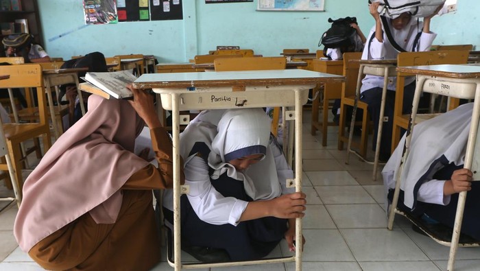 Anak Sekolah di Aceh Belajar Evakuasi Mandiri Gempa dan Tsunami Siswa Palang Merah Remaja (PMR) SMP Negeri 17 mengevakuasi rekannya yang cidera saat simulasi penanganan gempa dan tsunami di Banda Aceh, Aceh, Selasa (29/10/2024). Simulasi dan mitigasi yang melibatkan ratusan pelajar dan petugas Badan Penanggulangan Bencana Daerah (BPBD) tersebut dilaksankan sebagai upaya meningkatkan kesiapsiagaan dan pengurangan risiko serta korban jiwa akibat bencana. ANTARA FOTO / Irwansyah Putra/YU