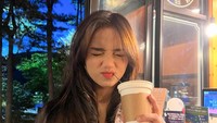 Liburan ke luar negeri, wanita bertubuh mungil ini sempatkan cicip minuman hangat. Kira-kira kopi atau hot chocolate ya? Foto: Instagram fuji_an