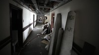 Di dalam, puing-puing menutupi lantai yang dulunya bersih. Sofa beludru yang pudar, kasur yang robek, dan jendela yang pecah adalah satu-satunya yang tersisa dari kemewahan yang pernah menjadi ciri khas bangunan tersebut pada masa jayanya.