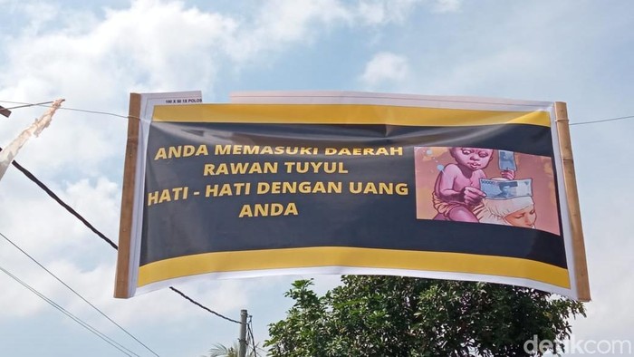 Spanduk peringatan rawan tuyul yang dipasang warga kampung di Jember