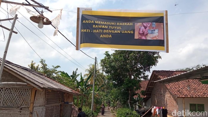Spanduk peringatan rawan tuyul yang dipasang warga kampung di Jember