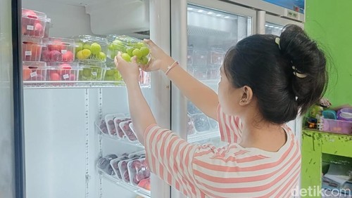 Pegawai Toko Bali Buah, Suriani saat menata stok anggur muscat di Jalan Katrangan, Denpasar, Bali pada Rabu (30/10/2024). (Ni Made Lastri Karsiani Putri-detikBali)